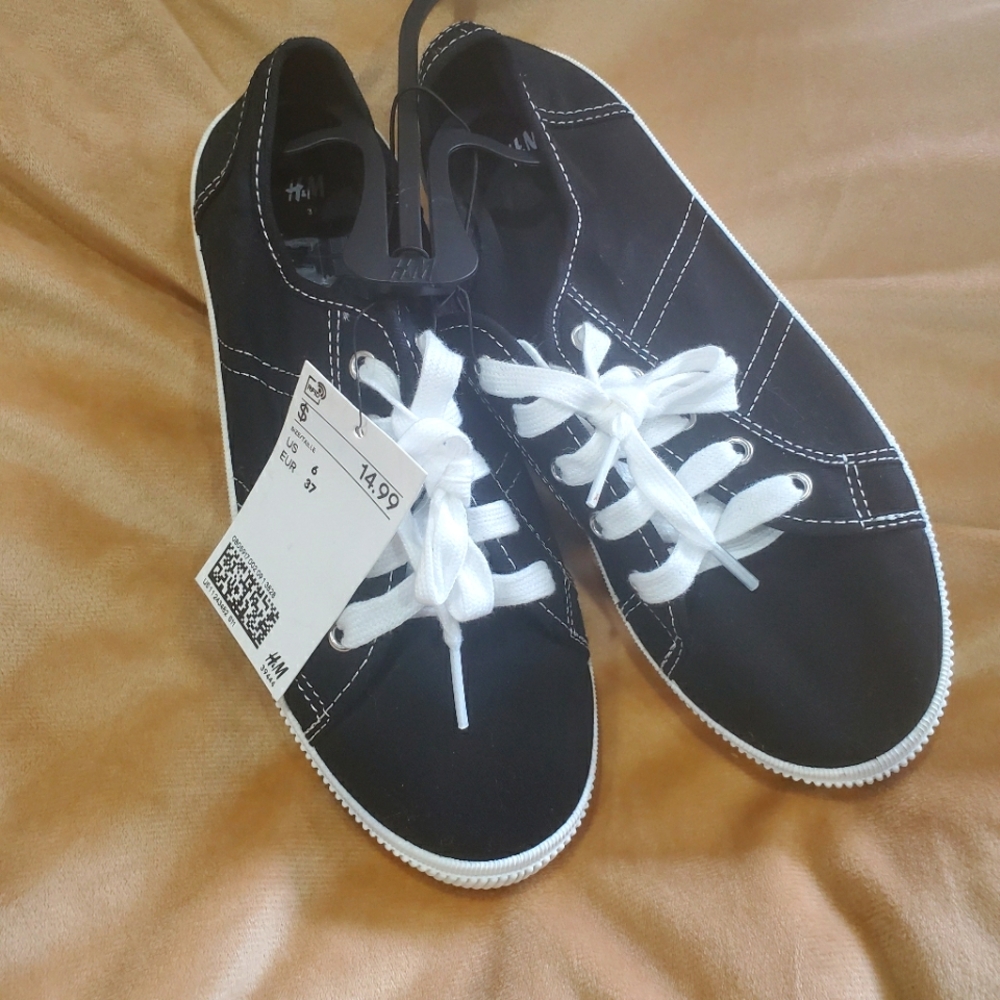 Black sneakers with white stitching